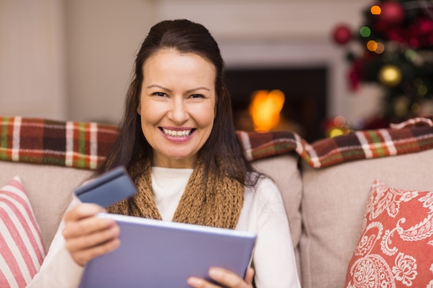 Brunette online winkelen met laptop met Kerstmis