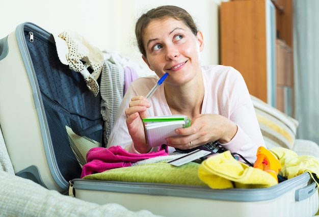 brunette planning vakantie met laptop