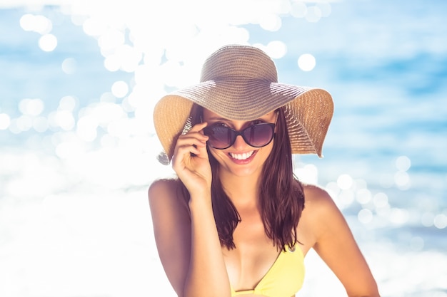 Brunette relaxing with a straw hat smiling at camera