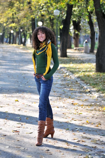 brunette Schattige jonge vrouw met kleurrijke sjaal poseren buiten in de natuur