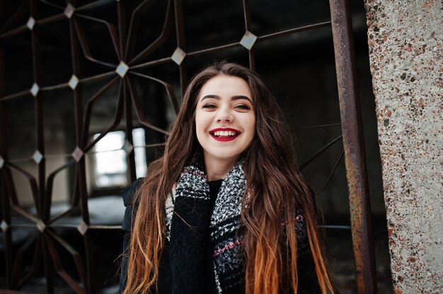 Brunette stylish casual girl in scarf against abandoned factory place.