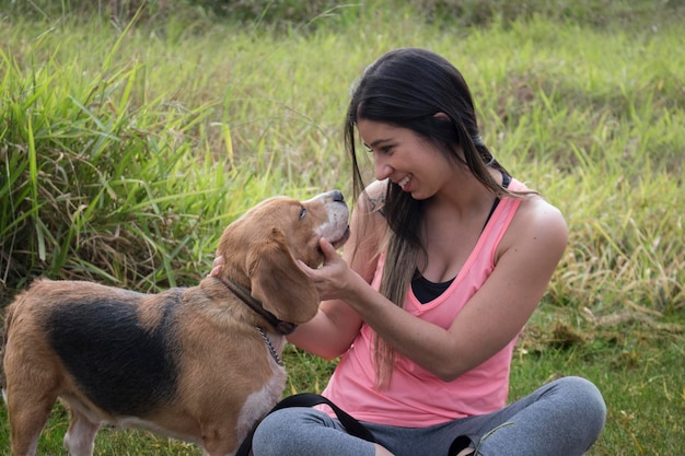 屋外の公園でビーグル犬とブルネットのティーンエイジャー