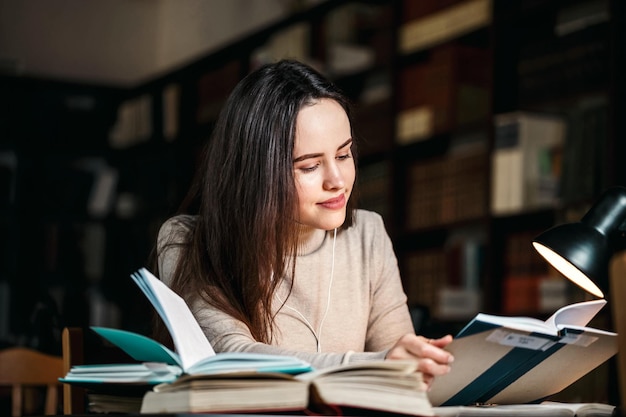 Brunette vrouw leest boek aan tafel met lamp