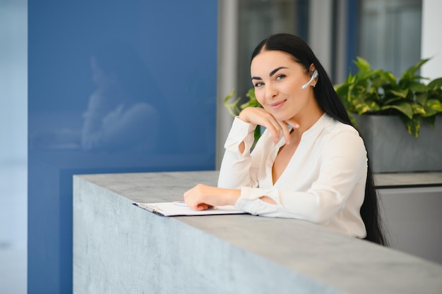 Brunette vrouw receptioniste werkt bij de receptie van de schoonheidssalon