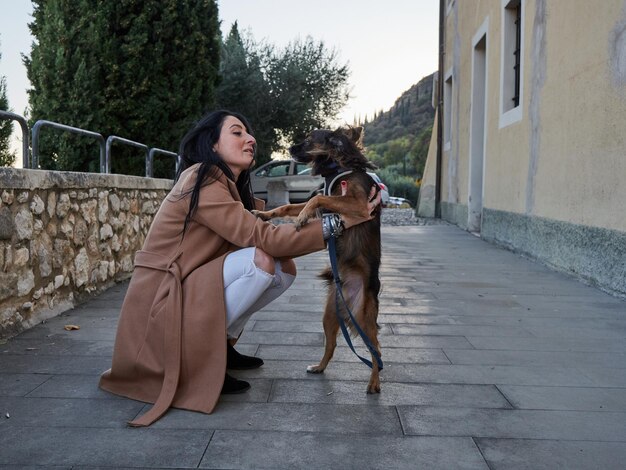 Brunette vrouw speelt met kleine hond