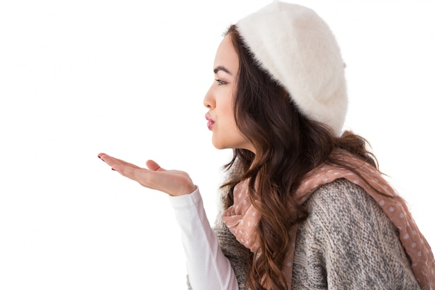 Brunette in winter clothes blowing kiss 