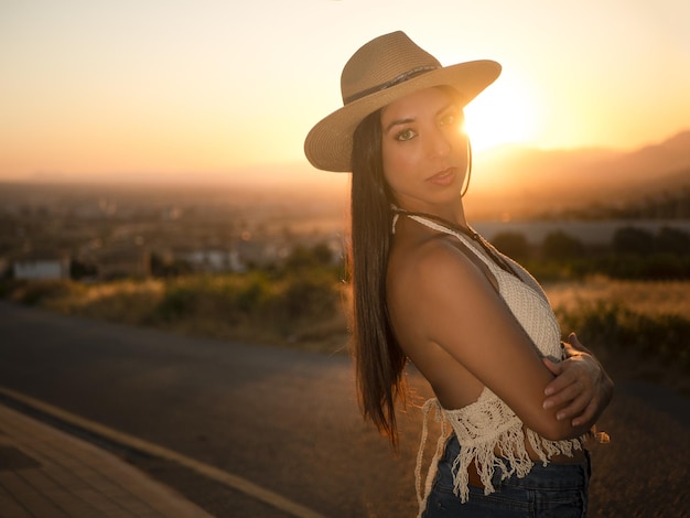 Brunette with folded arms at sunset