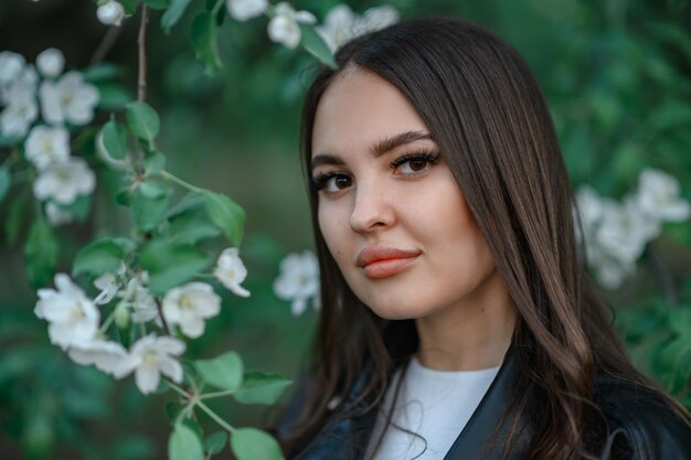 Brunette with long hair In the apple bushes in spring