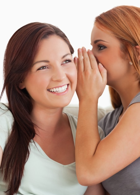 Brunette woman being told a secret