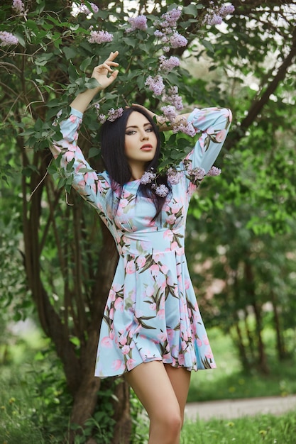 Brunette woman in the branches of a beautiful flowering tree