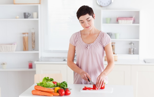 Brunette woman cutting vegetables