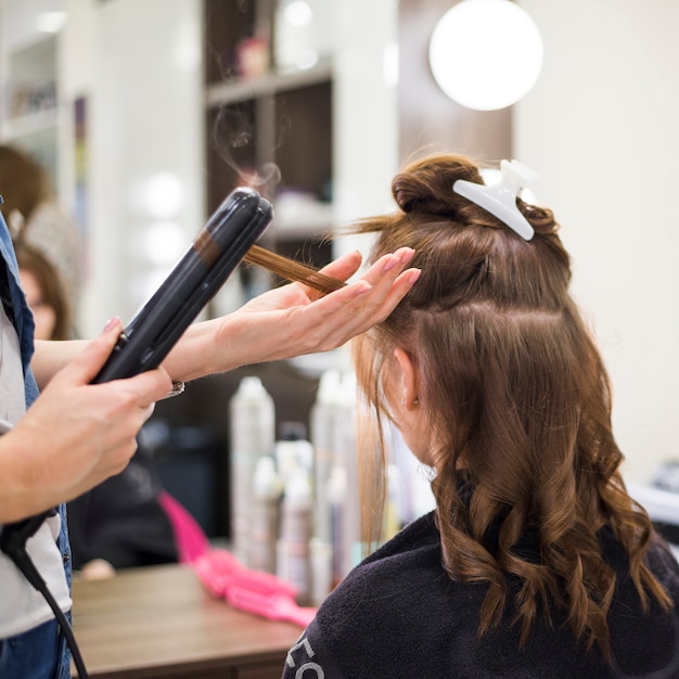 Donna castana che fa i suoi capelli fatti