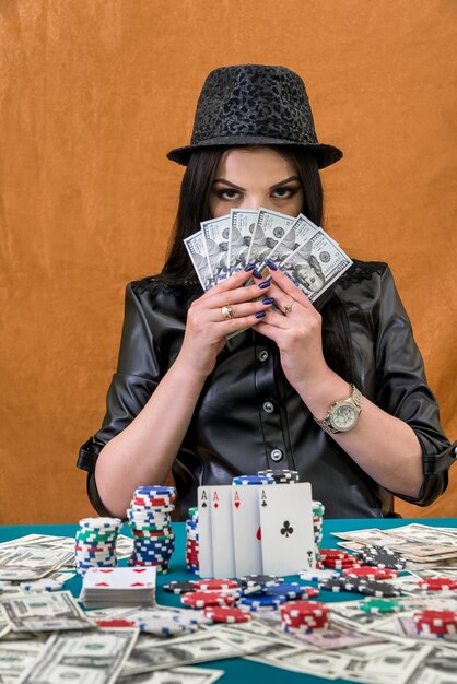 Brunette woman hiding her face under dollars fan