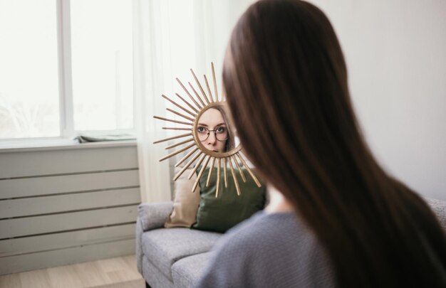 A brunette woman looks at herself in the mirror in the room. Psychological problems. Split personality