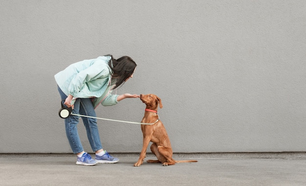 Brunette woman playing with a beautiful young dog