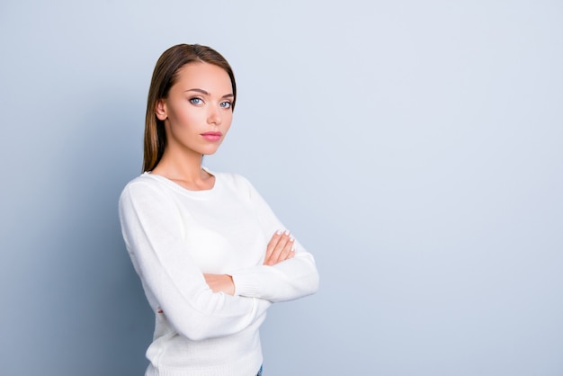 Brunette woman posing against the light blue wall