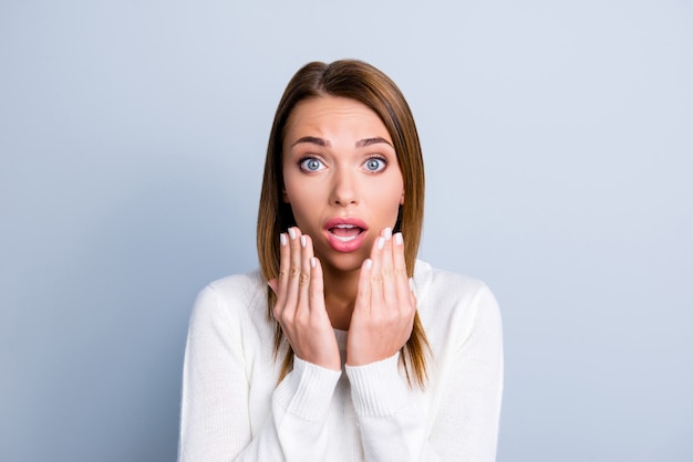 Brunette woman posing against the light blue wall