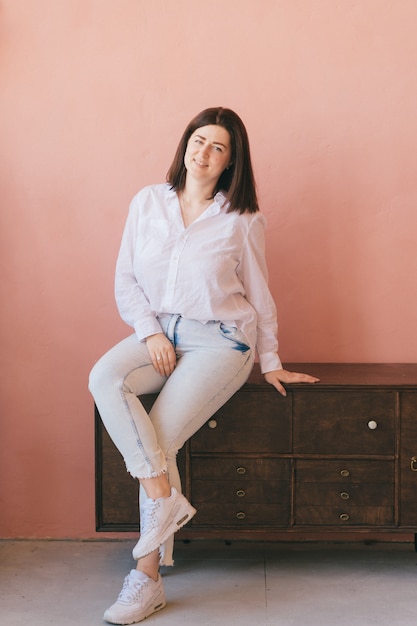 Brunette woman posing on pink background