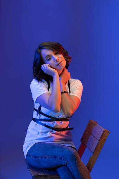 Foto donna castana che posa nello studio isolato sull'azzurro