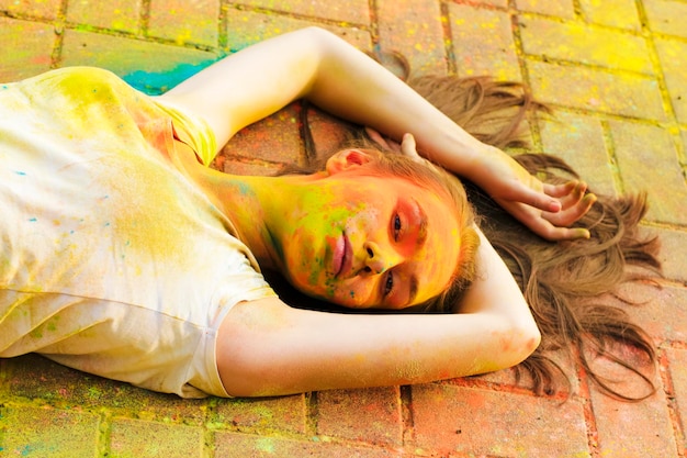 Brunette woman posing with colored powder on her face