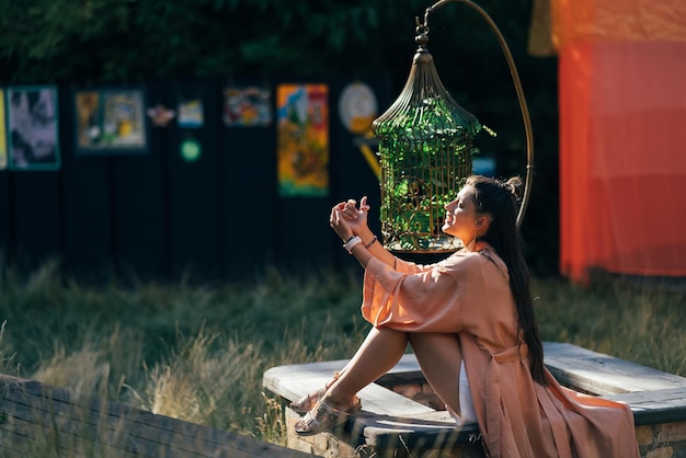 Foto donna castana che si siede sulla panchina e godersi il tramonto