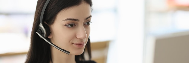 헤드을 착용 한 갈색 여성 은 사무실 에서 젊은 고객 을 듣고 있는 컴퓨터 모니터 를 보고 있다
