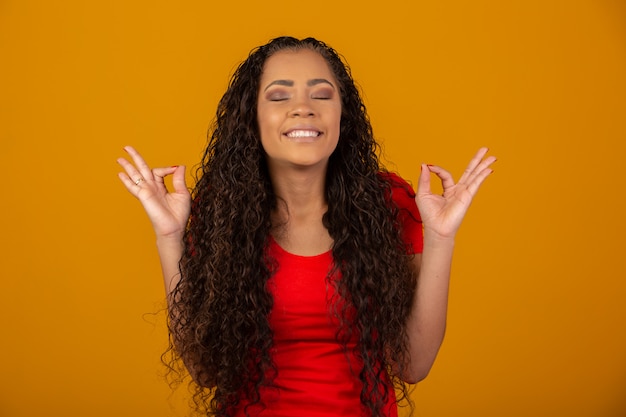 Brunette woman with long and shiny curly hair praying