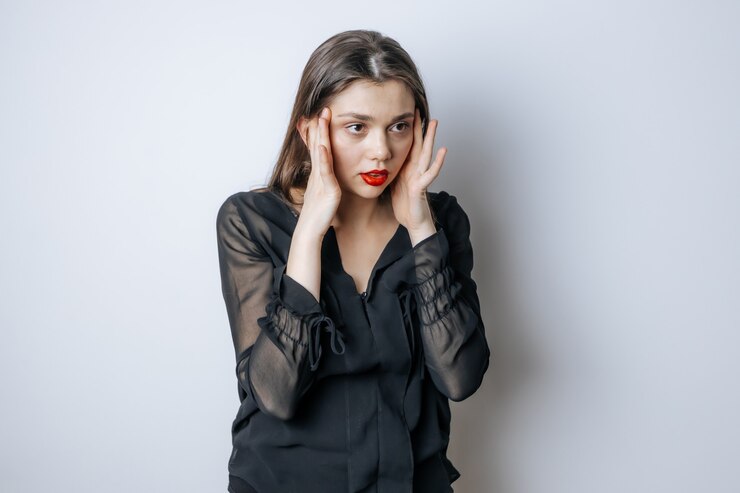Photo 赤い唇を持つブルネットの女性は彼女の頭に触れます
