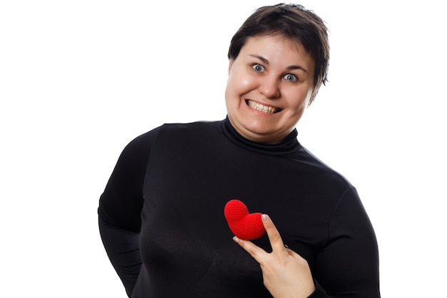 Brunette woman with short haircut holding red heart in her fingers isolated on white background