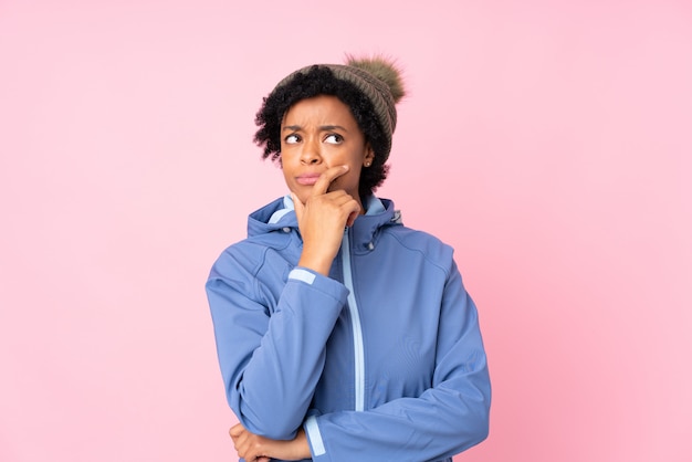 Brunette woman with winter hat over isolated blue background