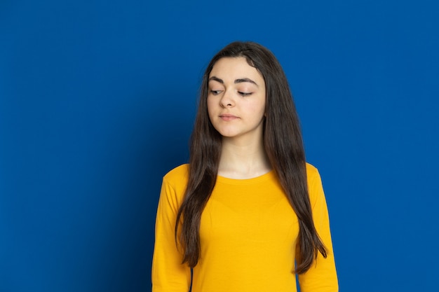 Brunette young girl wearing yellow sweatshirt