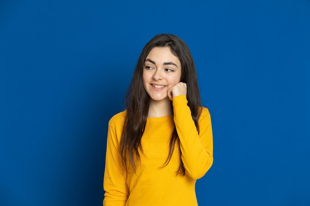 Brunette young girl wearing yellow sweatshirt