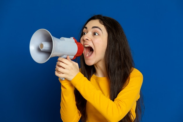 Brunette young girl wearing yellow sweatshirt