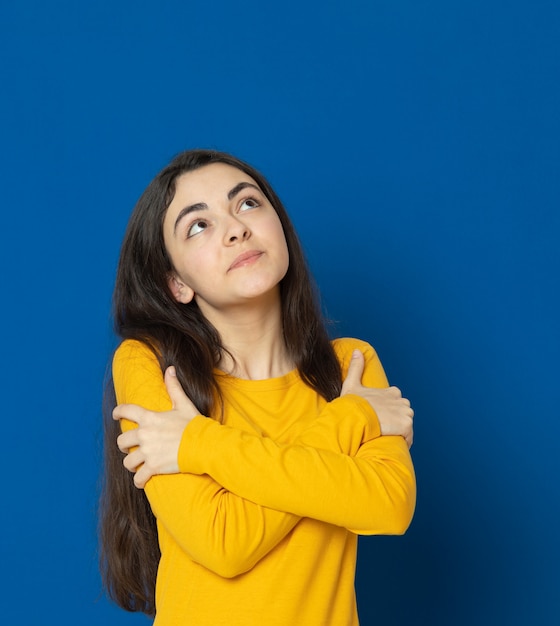 Brunette young girl wearing yellow sweatshirt