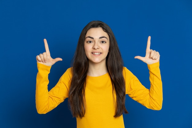 Brunette young girl wearing yellow sweatshirt