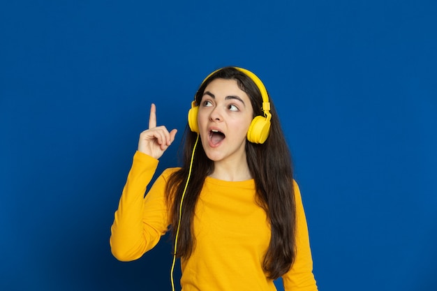 Brunette young girl wearing yellow sweatshirt