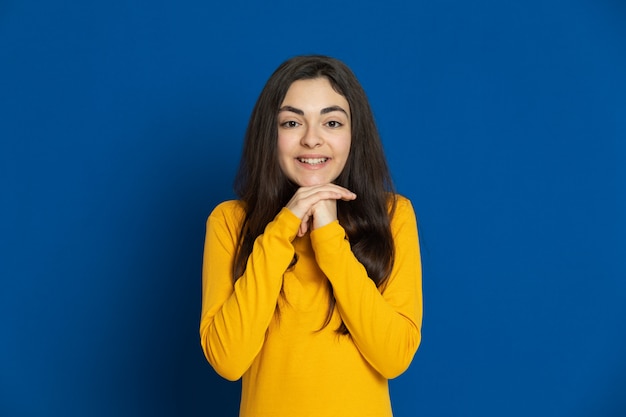 Brunette young girl wearing yellow sweatshirt