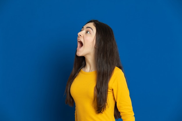 Brunette young girl wearing yellow sweatshirt