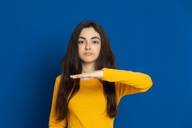 Brunette young girl wearing yellow sweatshirt