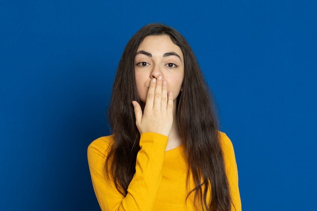 Brunette young girl wearing yellow sweatshirt