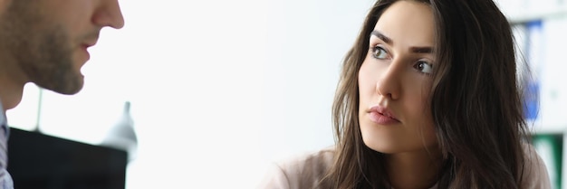 Brunette young woman face listening to her family doctor on appointment