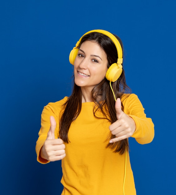 Giovane donna castana che gesturing sopra la parete blu