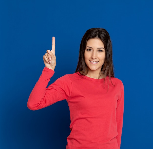 Brunette young woman gesturing over blue wall