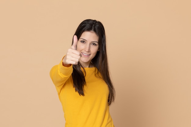 Brunette young woman wearing a yellow T-shirt