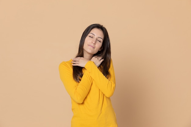 Brunette young woman wearing a yellow T-shirt