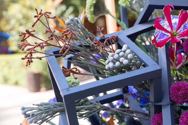 Foto brunia albiflora tak in een bloemstuk met blauwe houten lijsten het gebruik van exotische bloemen