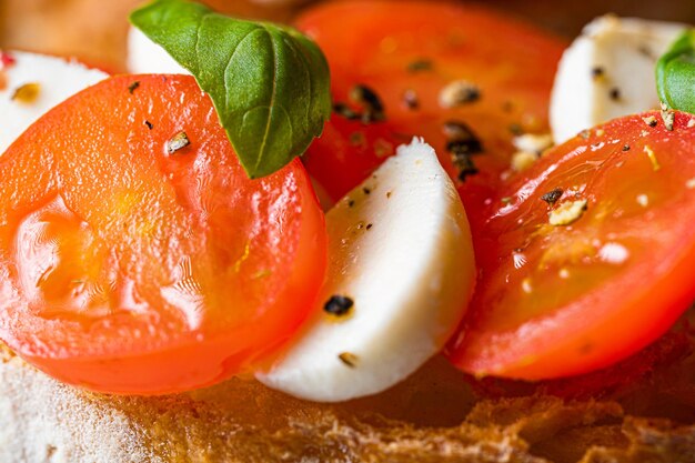 bruschetta caprese verse basilicumblaadjes rijpe aromatische tomaten en Italiaanse mozzarella op bruschetta besprenkeld met olijfolie en bestrooid met peper en kruiden