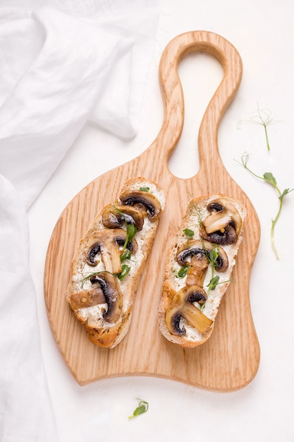 Bruschetta is a traditional Italian appetizer. sandwich with mushrooms and micro greens on a white background.