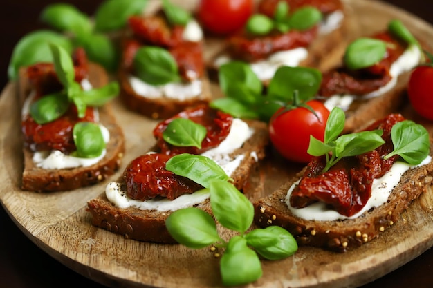 Bruschetta met gedroogde tomaten en basilicum Open sandwiches op roggebrood met tomaten