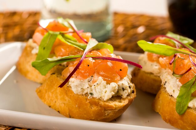 Bruschetta met gehakte mango, tuinkers en geitenkaas op vers stokbrood op tafel